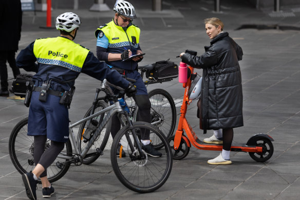 Senior Constable Paul Nichols writes an infringement notice for a rider not wearing a helmet on Monday.