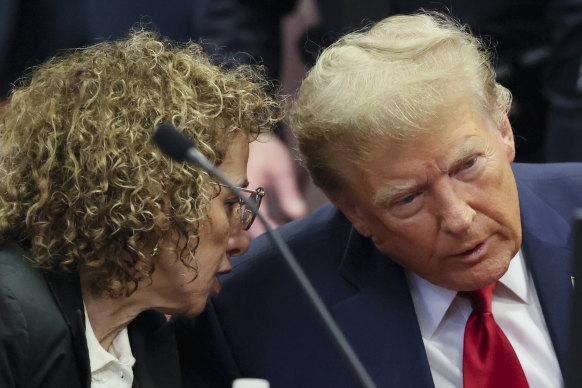 Trump consults with a lawyer during the hearing.