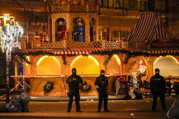Security guards stand in front of the cordoned-off Christmas market after a car crashed into a crowd of people, in Magdeburg, Germany.