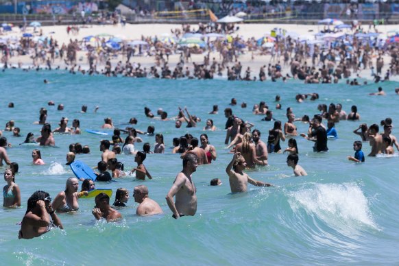 The wet get wetter: A busy Bondi Beach on Australia Day before storms reached the coastline.