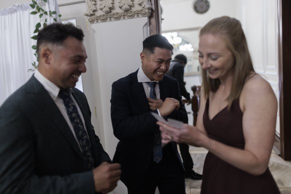 Teachers have a laugh checking out their photobooth pictures at the St Clare’s formal at Curzon Hall.