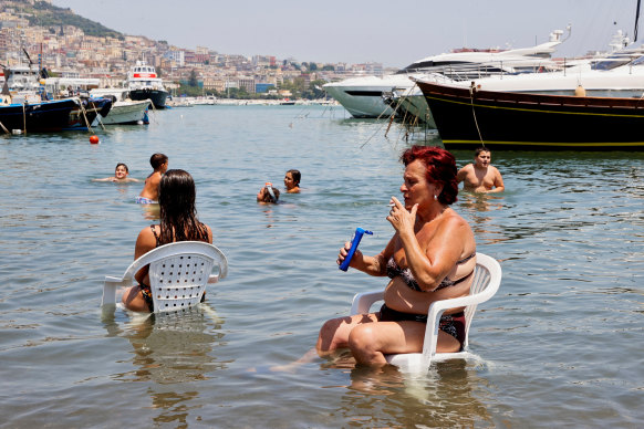A woman cools off as she sits in the sea during a heatwave across Italy earlier this week.