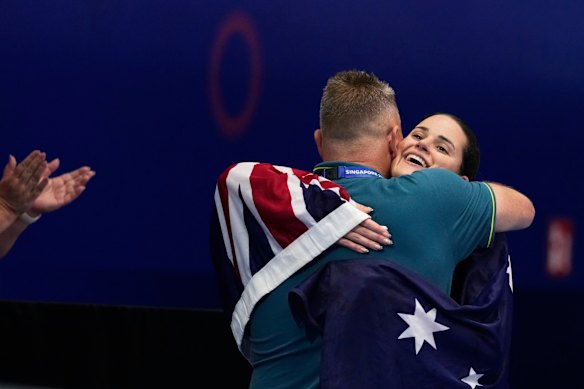 Kaylee McKeown hugs her coach Michael Sage after her victory in Singapore. 
