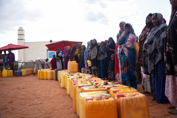 Families wait for trucked water to be distributed at the drought-affected village of Lumayo in Somaliland
