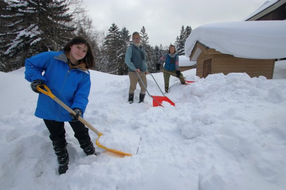 Grace, John and Lucy Morrell at their home in Hokkaido, Japan, digging out their storage shed in preparation for moving back to Australia.