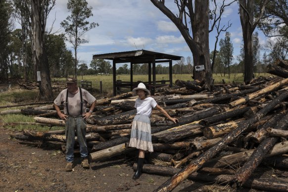 Bob Letondeur and Lorna Cameron inspect damage on Summerland Way, north of Grafton, after loose logs from a pine plantation swept through the area in floodwaters.