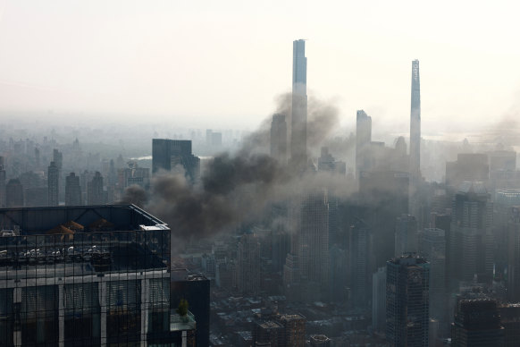 Smoke is visible after a construction crane caught fire on a high-rise building in Manhattan.