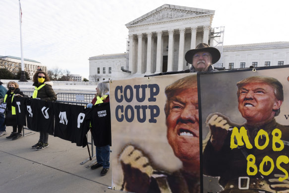 Protesters hold their banners in front of the US Supreme Court,