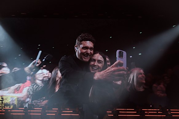 Buble takes a selfie with a fan at his Sydney show.