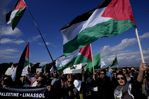 Protesters chant slogans while waving flags and banners condemning Israeli military operations inside the Gaza Strip, outside the entrance to RAF Akrotiri, near the southern coastal city of Limassol, Cyprus.