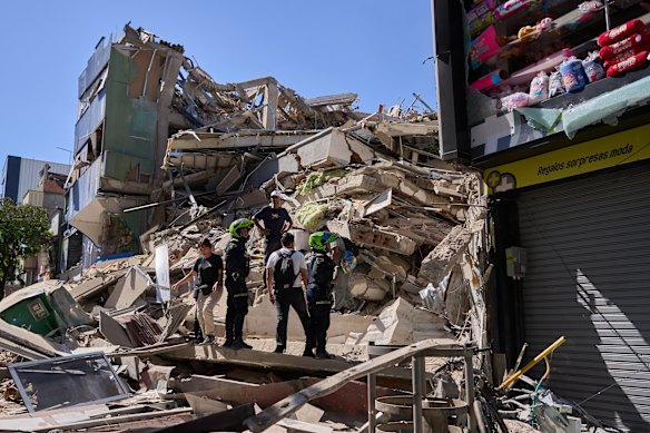 Police look at a building damaged after an earthquake struck Colombia.
