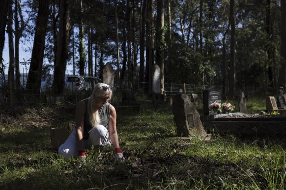 Glenda Bouchard looks over her late husband’s grave at the Cambewarra West Cemetery. Glenda arrived to find the grave covered in mud and debris from recent flooding. 