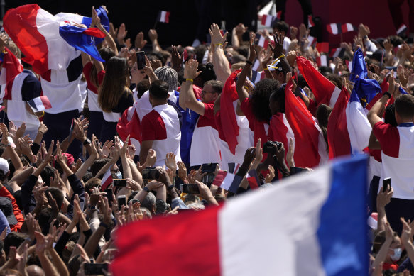 Fans wave French flags and cheer in the Olympics fan zone at Trocadero Gardens in front of the Eiffel Tower in Paris on Sunday.