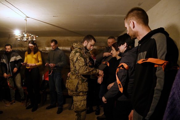 Combat paramedic Vsevolod Dorofeyev (centre) demonstrates the use of a tourniquet to civilians during a trauma medical training session.