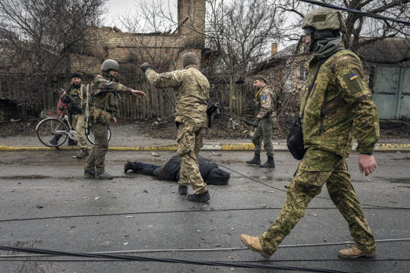Ukrainian servicemen check for booby traps in bodies, homes and abandoned equipment after Russian forces attacked the Kyiv suburb of Bucha.