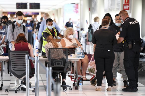 Police screen passengers arriving at Brisbane Airport’s domestic terminal in December.