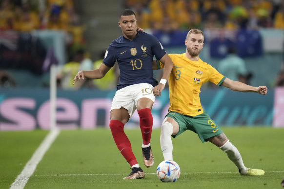 Kylian Mbappe and Nathaniel Atkinson fight for the ball.