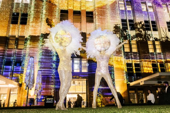 Performers the Huxleys strike a pose in front of Barerarerungar by Maree Clarke at the Museum of Contemporary Art Australia.