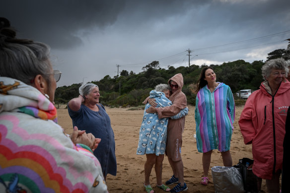 Members of The Sea Wolves embrace as they gather at South Beach for an early morning ocean swim.