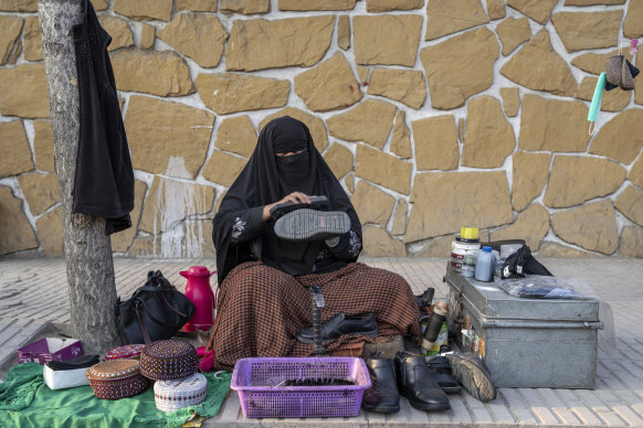 An Afghan woman cleans shoes in a street in Kabul, Afghanistan, last month. After the Taliban came to power in Afghanistan, women have been deprived of many of their basic rights. 