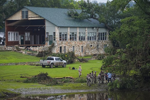 As autoridades procuram os terrenos de Camp Mystic, onde um edifício tinha uma parede lavada.
