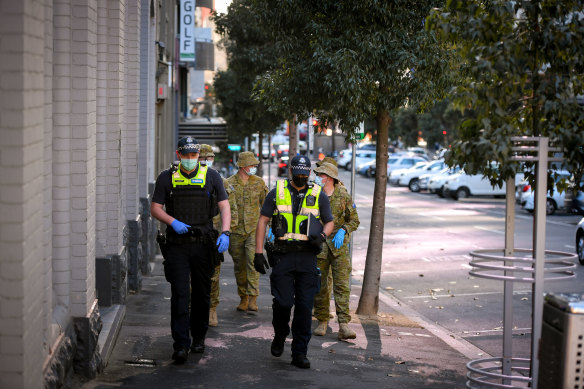 Victoria police and military personnel patrolling Melbourne.