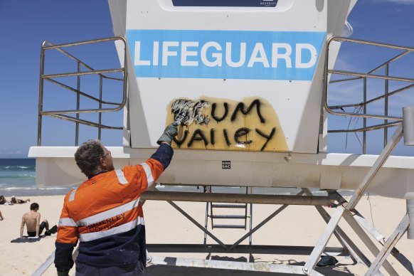 Anthony Ennis from Waverley Council cleans off graffiti from a Bondi lifeguard tower.