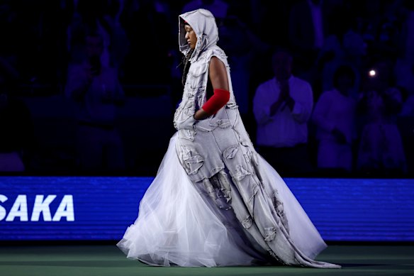 Osaka wore a sweeping white tulle skirt and grey terry hoodie bearing charred newspaper clippings of her successes.  