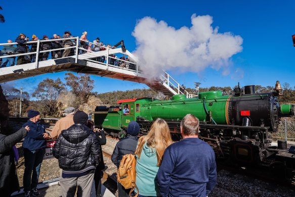 Train buffs gather to snap the historic railway as it zooms past.
