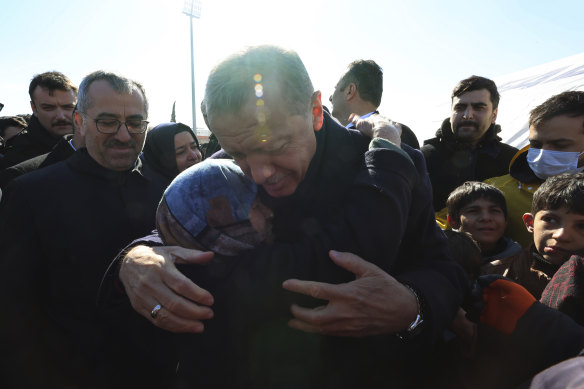 Türkiye Cumhurbaşkanı Recep Tayyip Erdoğan, geçen ay meydana gelen depremlerle harap olan Kahramanmaraş'ta bir kazazedeyi kucaklıyor.