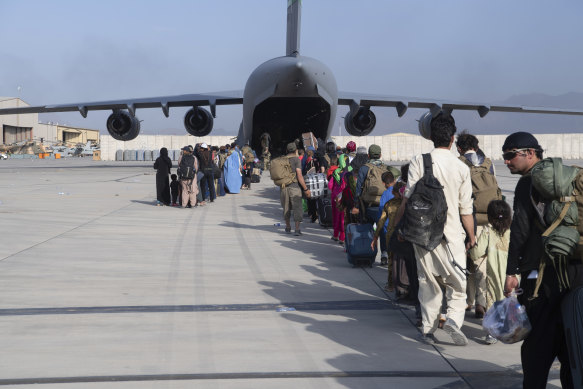 A US Air Force on loads people being evacuated from Afghanistan onto a C-17. 