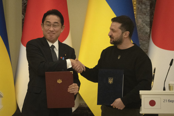 Japanese Prime Minister Fumio Kishida and Ukrainian President Volodymyr Zelenskyy, right, greet each other after the signing of joint documents in Kyiv.