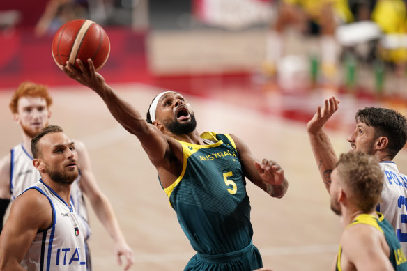 Patty Mills (centre) drives to the basket against Italy.
