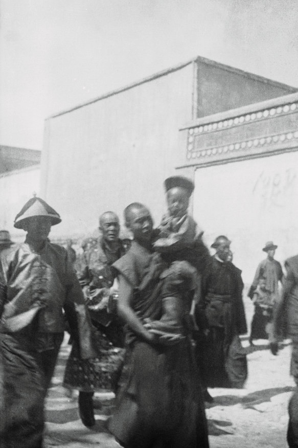 An attendant carries the new Dalai Lama as he prepares to journey across the Himalayas to Lhasa, Tibet. Years later, he would flee to north India.