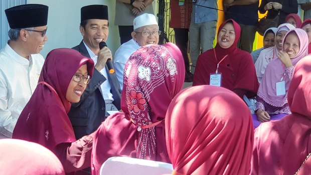 Joko Widodo addresses residents in Serang, Banten, accompanied by the chairman of the Financial Services Authority, Wimboh Santoso, and the head of Indonesian Ulema Council Ma'ruf Amin. 