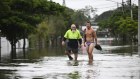 Local residents wade through flood waters in Tingalpa on Brisbane’s Eastside.