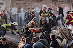Rescuers carry out an injured man from an apartment building in Pryluky, Ukraine, hit during a Russian air attack on Wednesday, October 7.