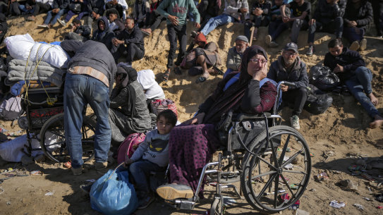Displaced Palestinians wait near a roadblock after being stopped from returning to northern Gaza.