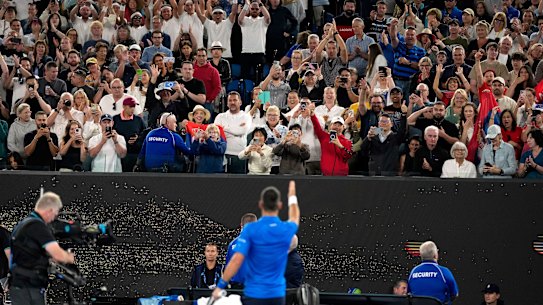 Novak Djokovic points to a heckler after defeating Tomas Machac in the third round.
