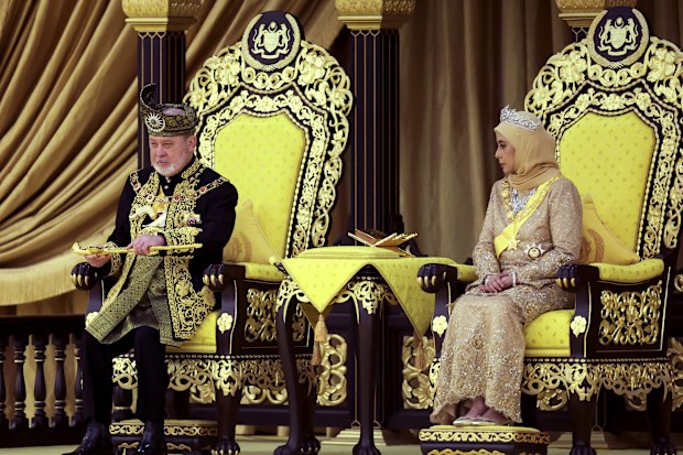 The 17th King of Malaysia, Sultan Ibrahim Iskandar, left, lifts a ceremonial dagger as Queen Raja Zarith Sofiah looks on during his coronation at the National Palace in Kuala Lumpur, Malaysia, Saturday, July 20, 2024. (Hasnoor Hussain/Pool Photo via AP)