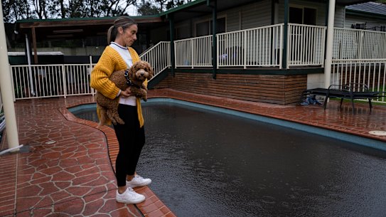 Kristy Lakeman next to her pool, which is black with coal dust, at her Russell Vale home.