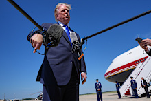 US President Donald Trump talks with reporters after an emergency inflatable slide deployed on Air Force One.