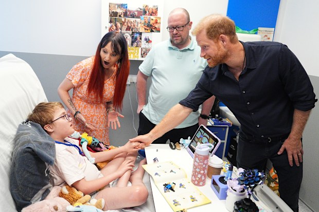 Prince Harry, Duke of Sussex, Patron of WellChild, meets patient Alec Hill, 12, who has a rare chromosomal condition and a rare immune system disease, and is in a wheelchair as a result of brain damage, with his mother Kelly Hill and father Stuart Hill