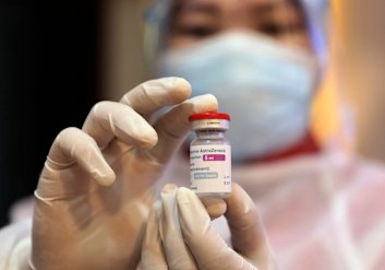 A health worker shows a vial of the AstraZeneca’s COVID-19 vaccine in Surabaya, East Java.