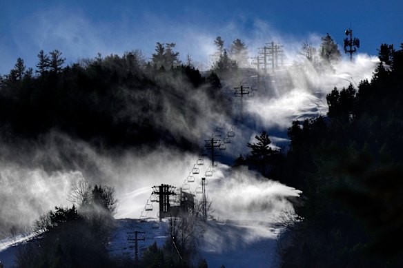 Man-made snow is blown from snowmaking equipment near the summit of Pleasant Mountain ski resort in Bridgton, Maine.
