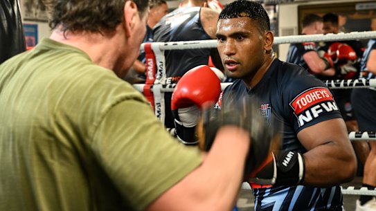 Tevita Pangai jnr spars with Mark Carroll in Origin camp on Tuesday.