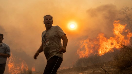 A local reacts as the flames burn trees in Gennadi village, on the Aegean Sea island of Rhodes in Greece on Tuesday.