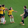 Mackenzie Arnold (right) embraces her Matildas teammates after Australia won the penalty shootout against France in the World Cup quarter-final.