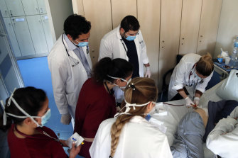 Medical students at Greece's Sotiria Hospital watch Dr Katerina Bakiri as she performs a minor operation.