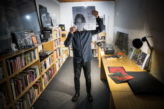 Marco Fusinato in his West Melbourne studio with a copy of his Italian passport picture.